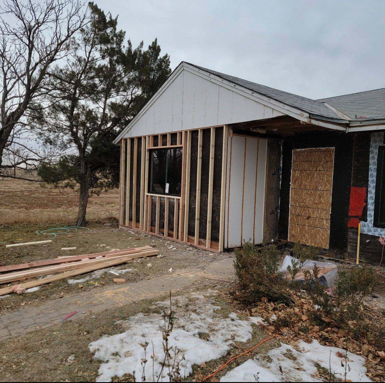Home addition under construction with exposed framing and white sheathing