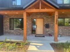 Covered patio with wooden beams attached to brick home exterior