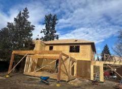 New house construction with yellow exterior framing and wooden structural supports